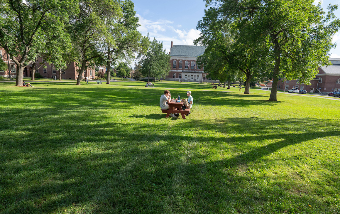 A photo of students sitting at a picnic table on the mall