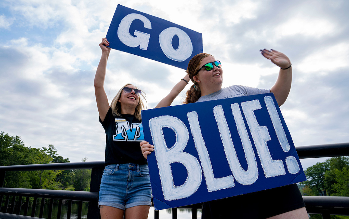 A photo of students holding up a "go blue" sign