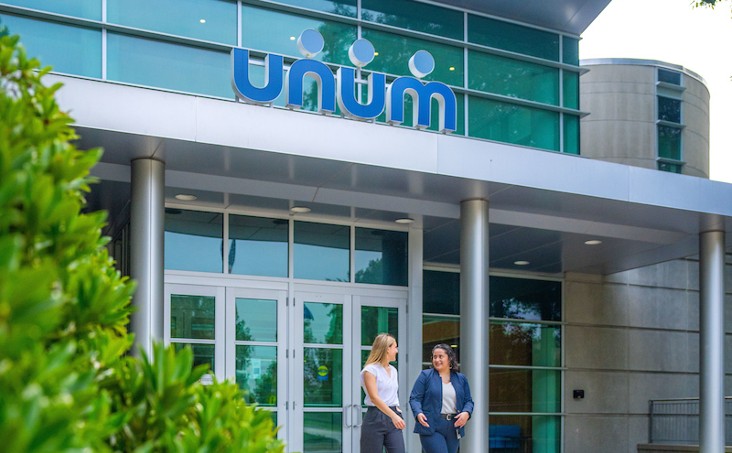 A photo of two people walking outside of Unum