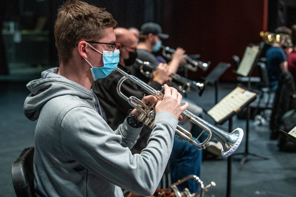Masked student plays the trombone