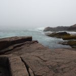 Photo of the ocean, along a rocky shore. Artist is Amanda Moline.