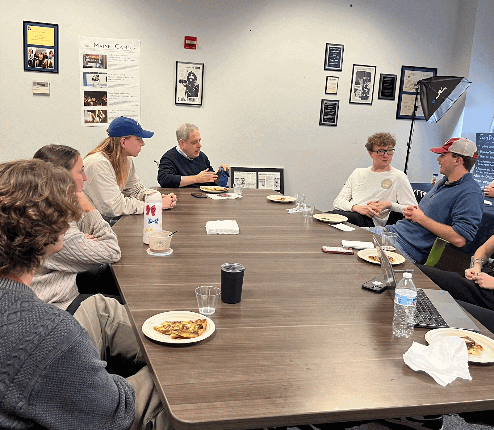 Journalist Ken Belson at a conference table conversing with student journalists