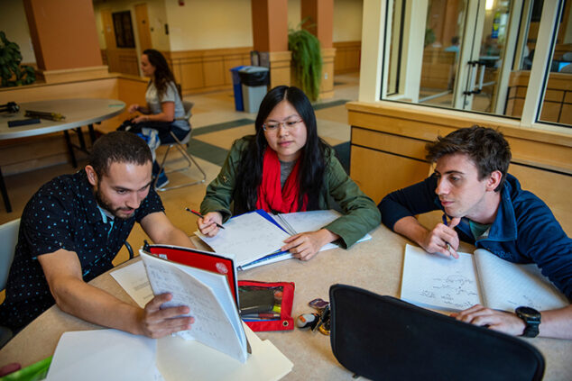 group of three students studying at table