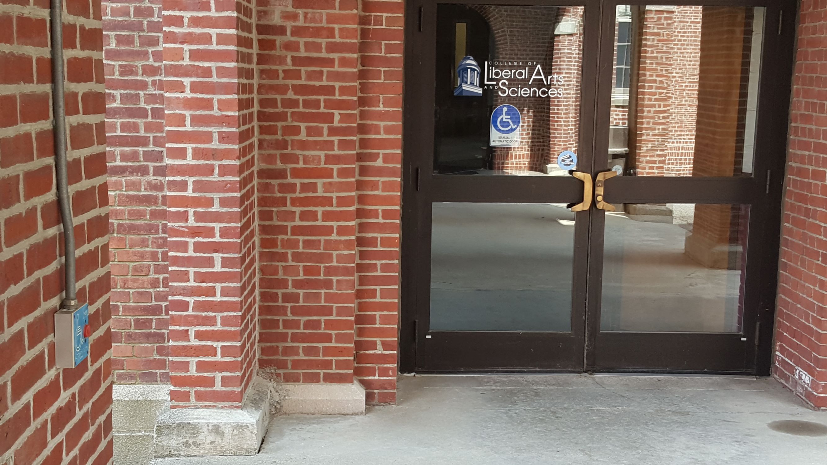 Photo of the accessible entrance to Stevens Hall. Automatic door with abutton on the left column to open.