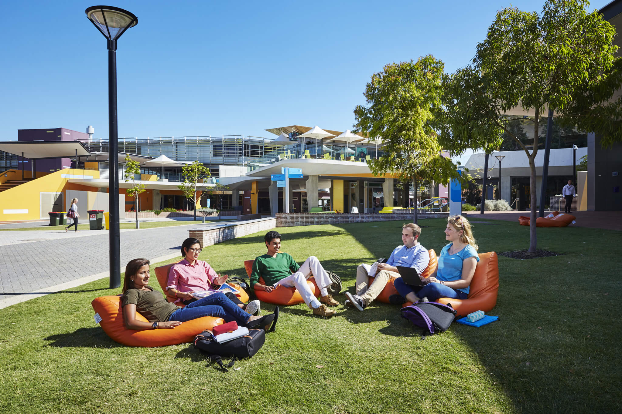 Students sitting on the grass at Edith Cowan university
