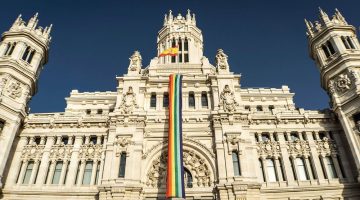 Cibeles Palace in Madrid, Spain with a rainbow flag.
