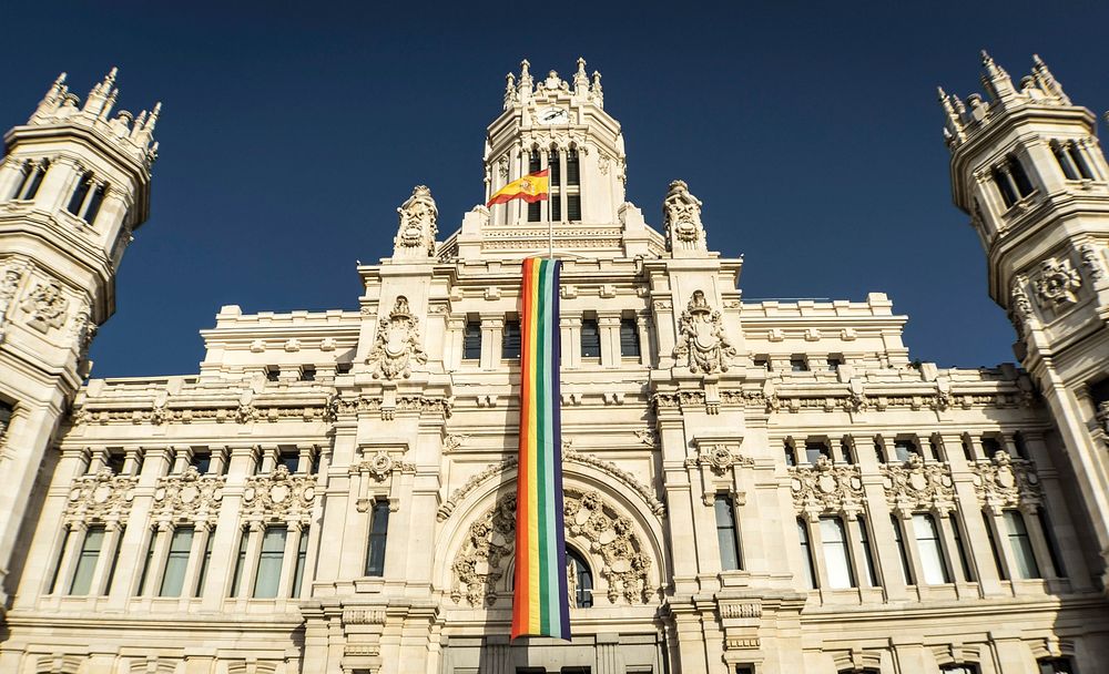 Cibeles Palace in Madrid, Spain with a rainbow flag.