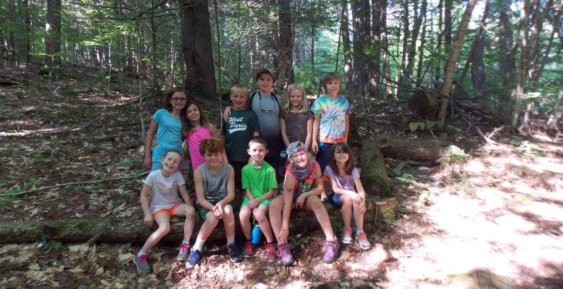Kids standing in a the woods at a summer camp in Maine