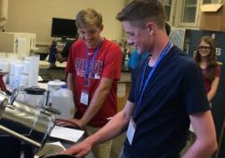 Male teen looking at engineering equipment at a summer camp in Orono Maine