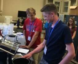 Male teen looking at engineering equipment at a summer camp in Orono Maine