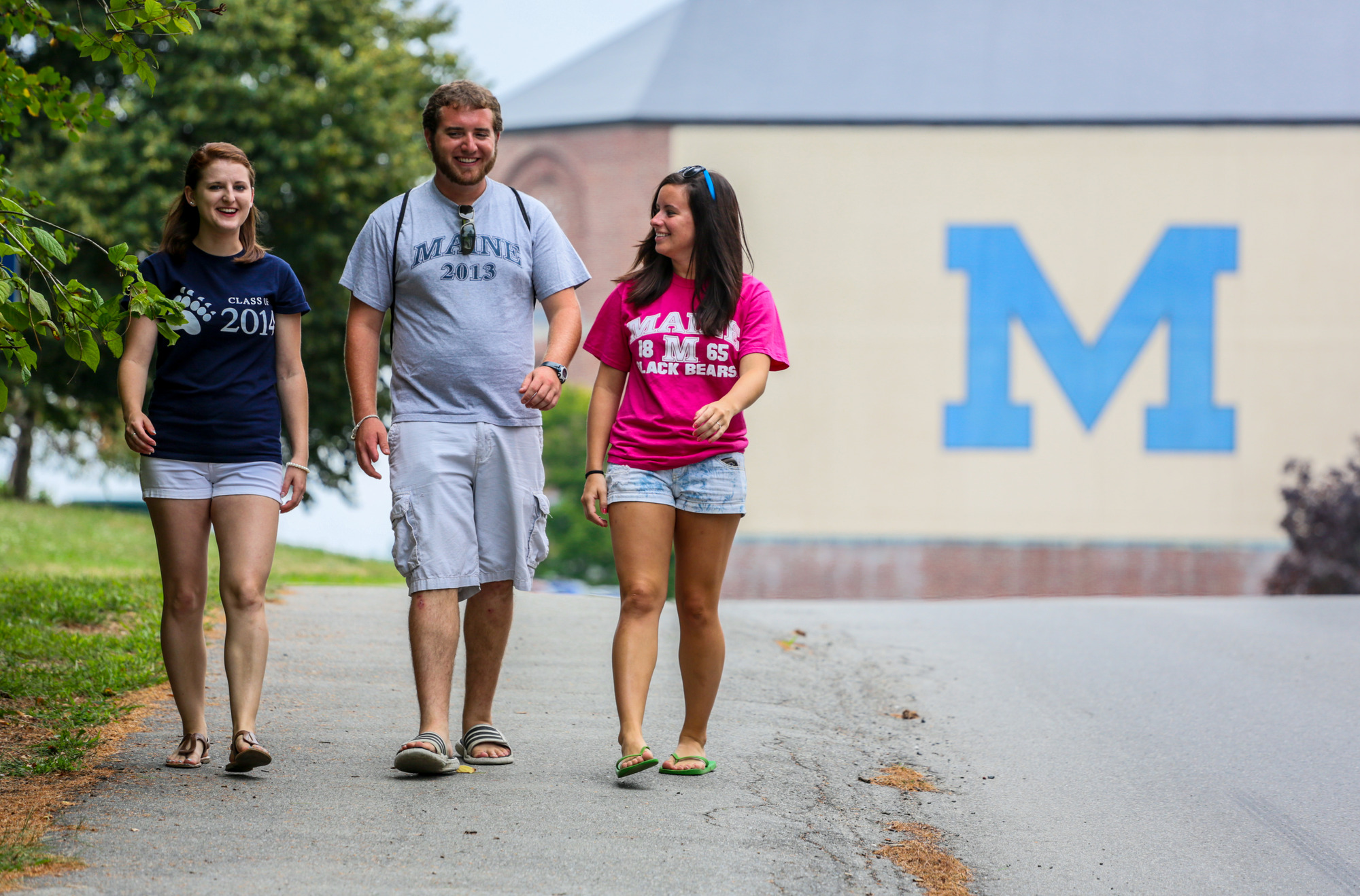 three students with UMaine t-shirts in fron of fieldhouse