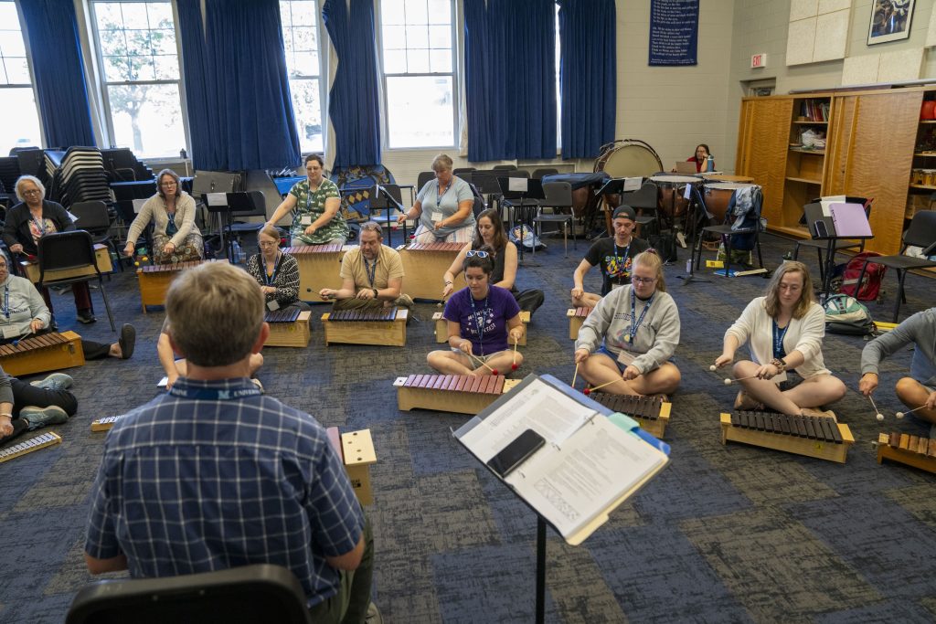 Music teachers playing instruments at a conference