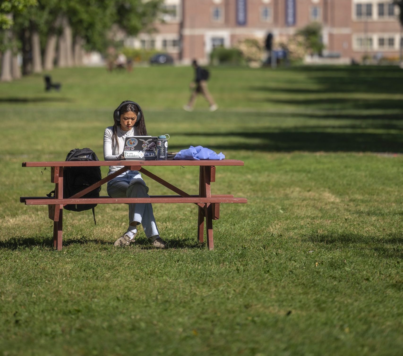 Student studying on a picnic table on the mall.