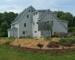 The outside of the Terrell House showing the garden and solar panels