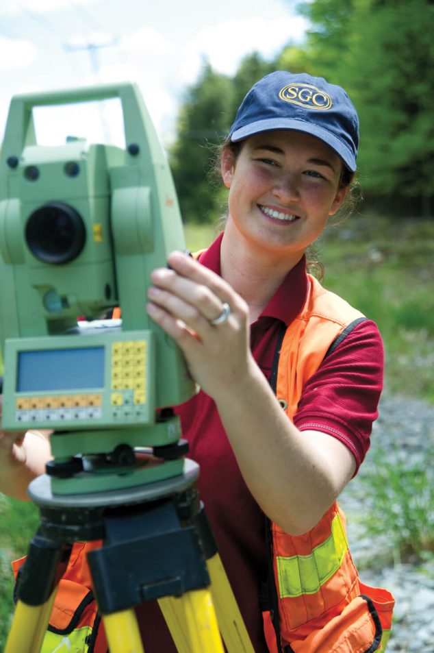 young woman surveyor looking through instrument