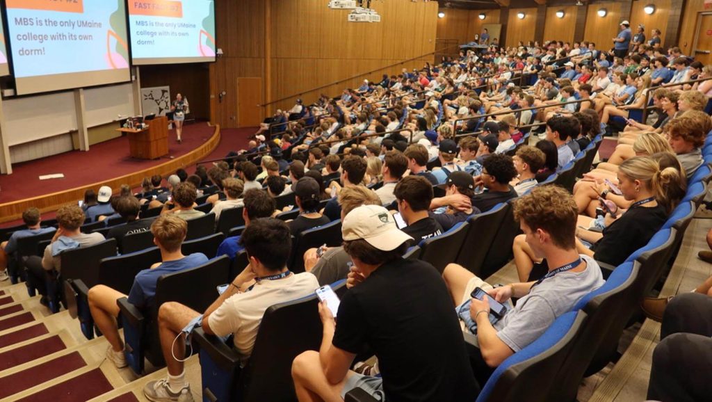 A photo of students in a large lecture hall in D.P. Corbett Business Building on UMaine's campus