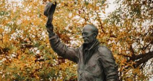 Harold Alfond statue with foliage.