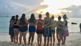 students back to on beach in Mexico at sunset