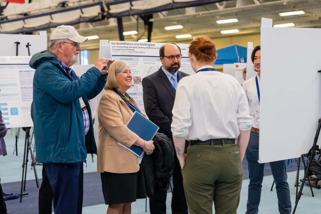 President Ferrini-Mundy and other faculty/staff view student presentations at UMSS24