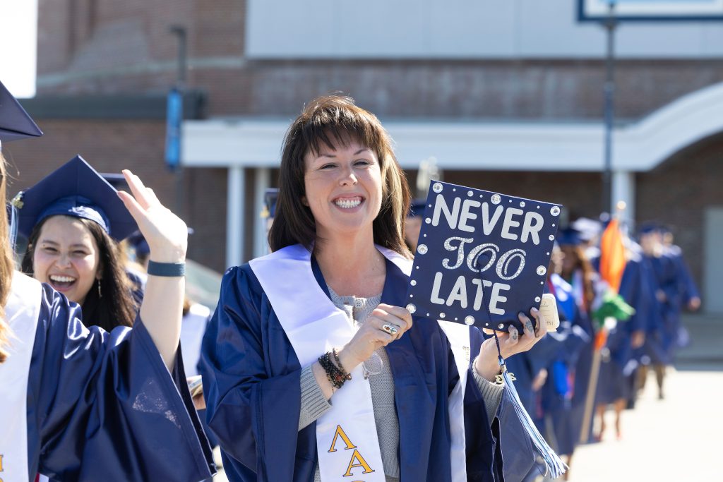 ADULT WITH GRADUATION CAP THAT SAYS NEVER TOO LATE