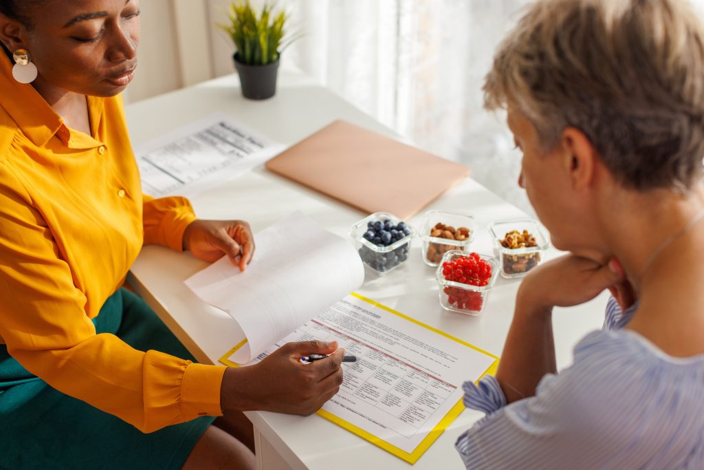 Female nutritionist discussing with her client about fruit portion in diet.