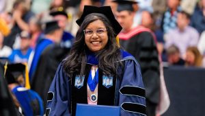 A photo of a doctoral graduate holding their diploma