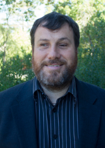 Headshot of Dr. Nicholas Giudice. He is wearing a blue striped shirt and a navy blue blazer.