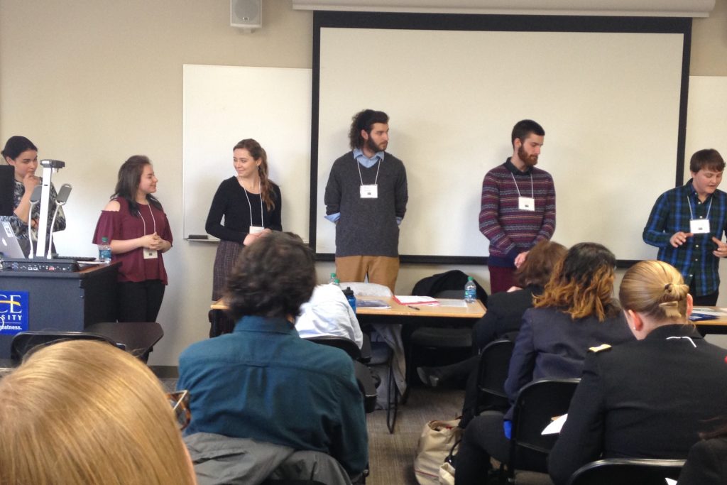 Tutors look on as Parker Midura presents