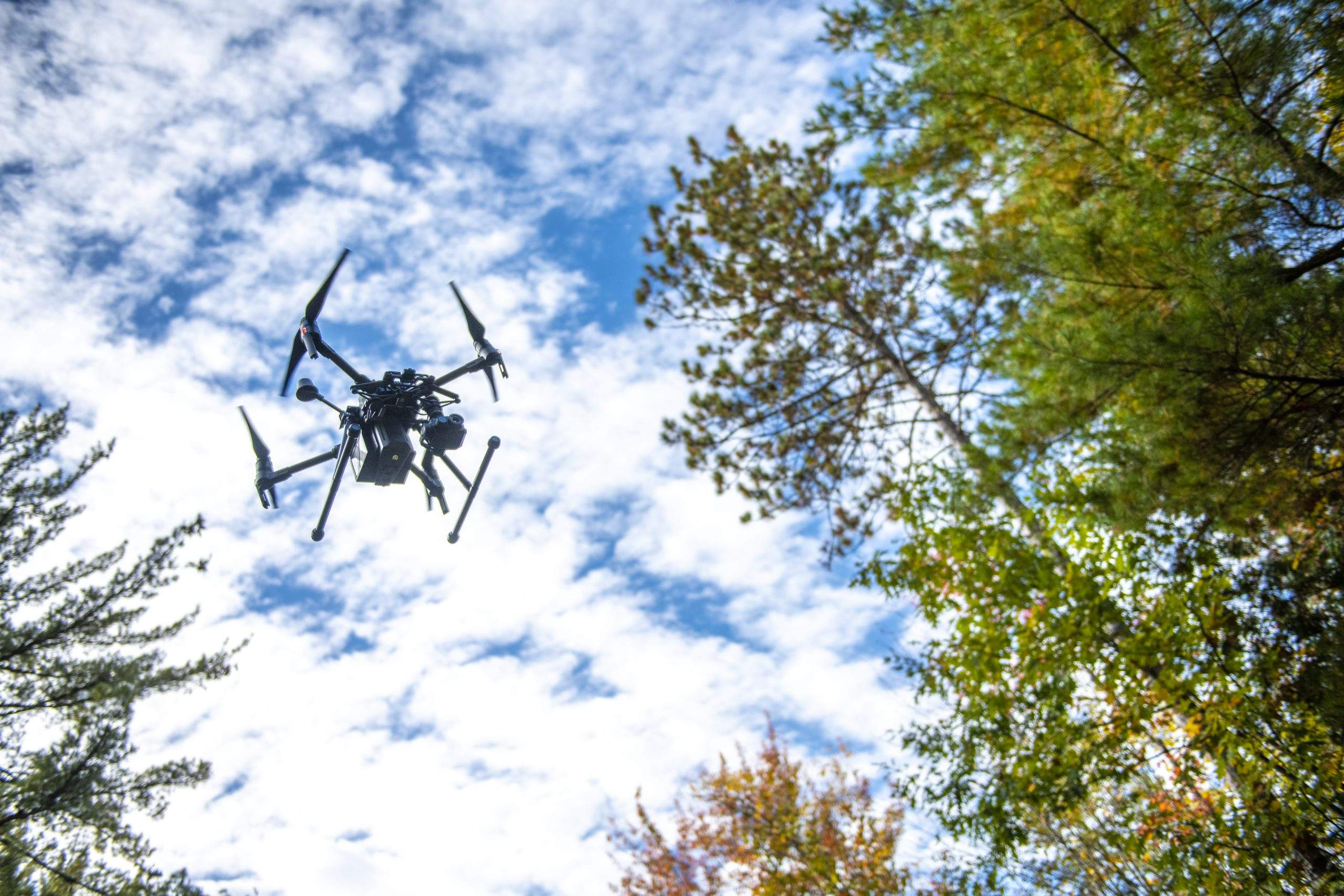 UAV in flight with surrounding trees