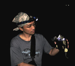 Agus holding a turtle at night.