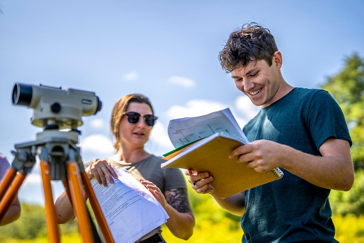 A photo of a student and professor in the field