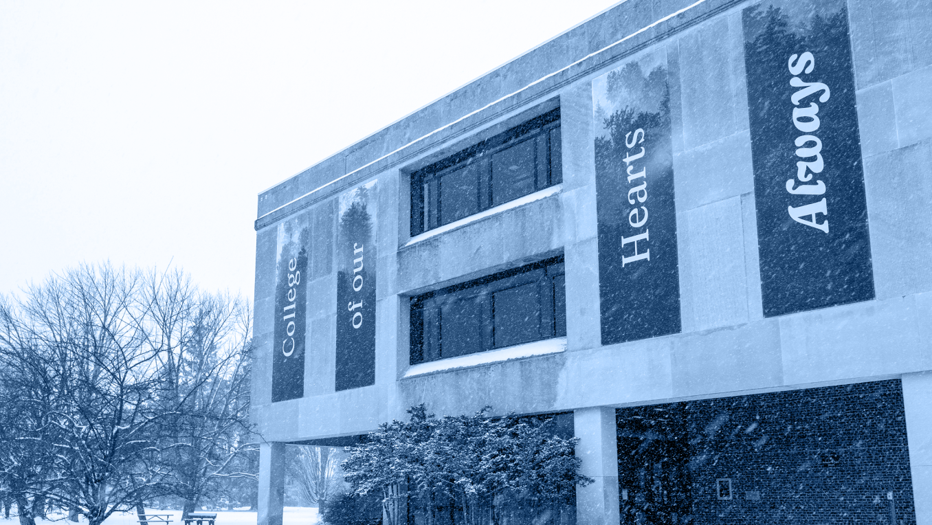 An image of snowy Fogler Library with banners that read "College of Our Hearts Always"