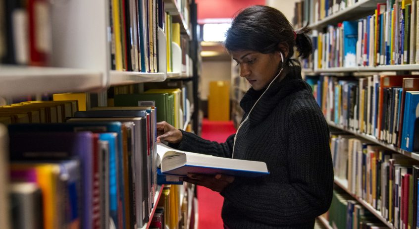 Woman looking at books in the library