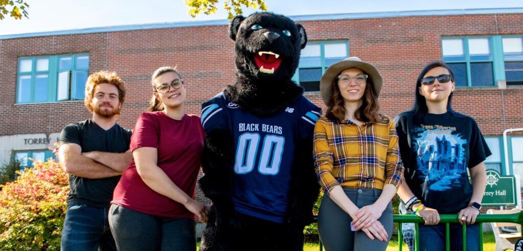 Students on the Machias campus pose with Bananas the bear
