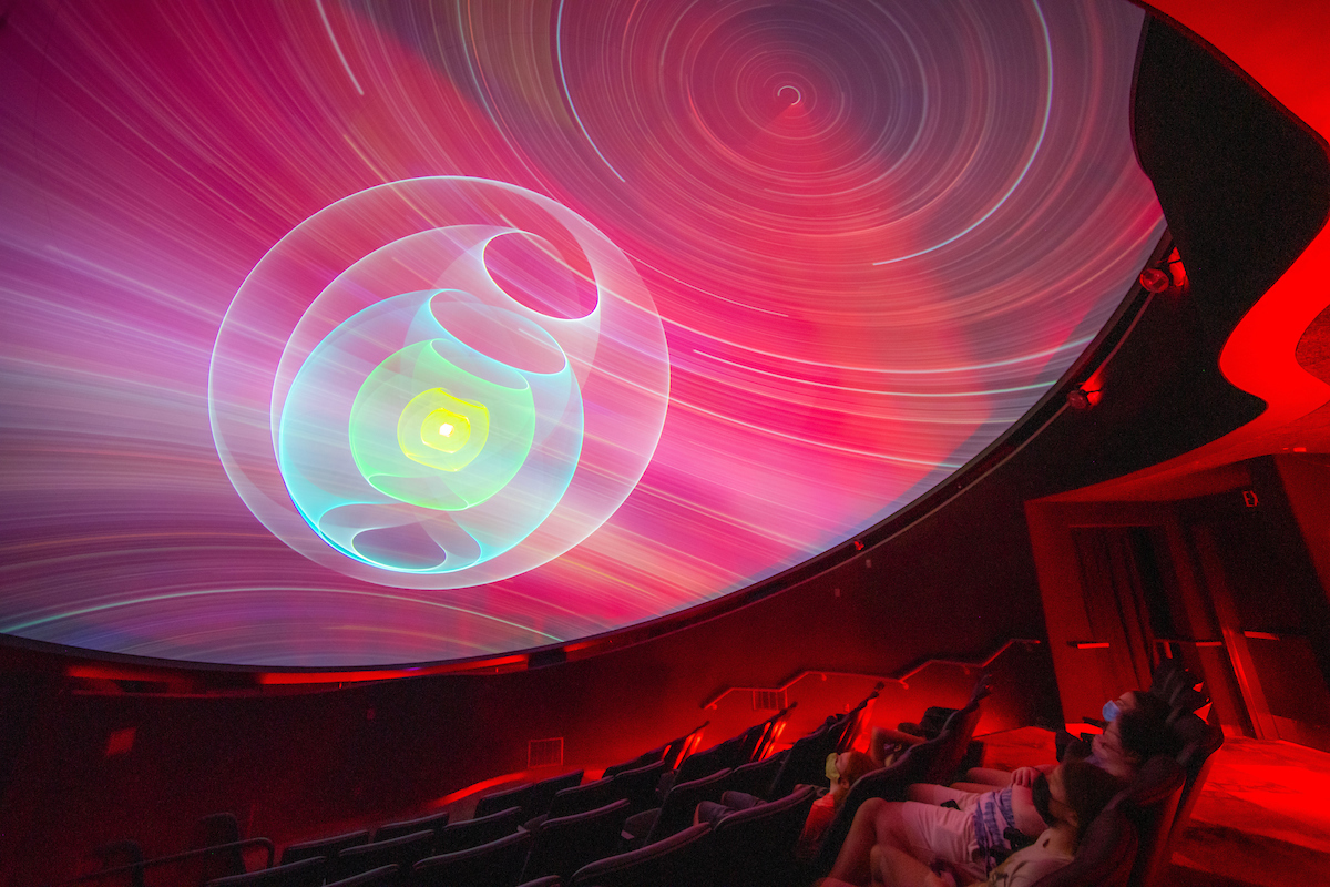 A photo of students looking at an image in the planetarium