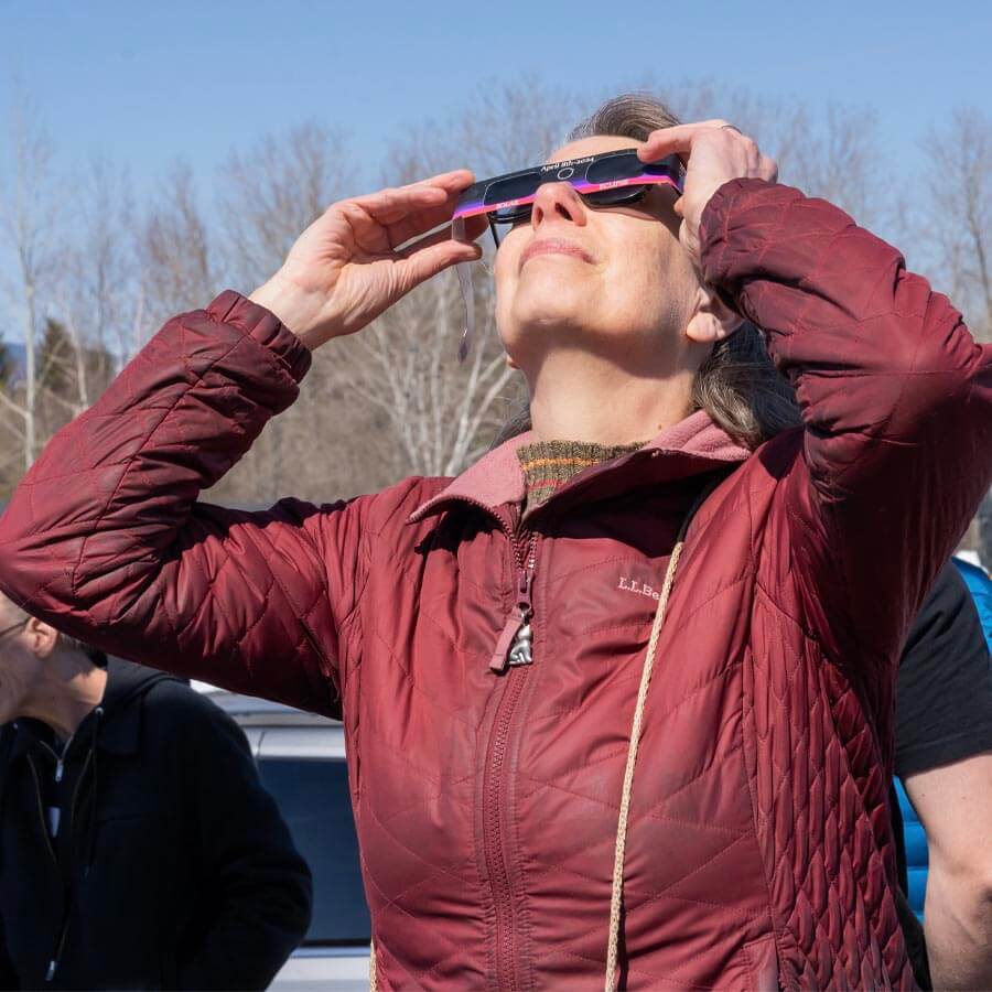 A photo of a person using eclipse glasses to view a total solar eclipse