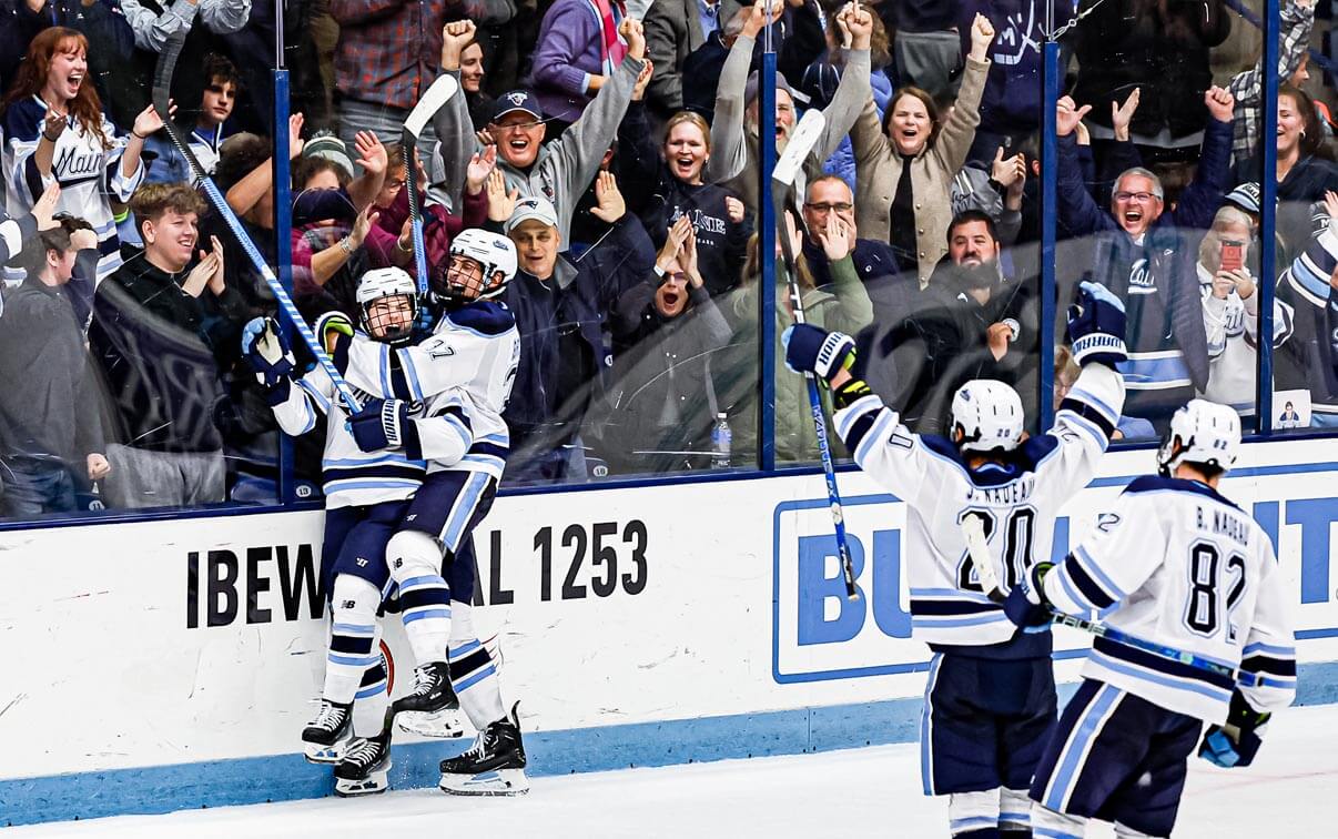 A photo of Men's Ice Hockey players celebrating after a goal is scored