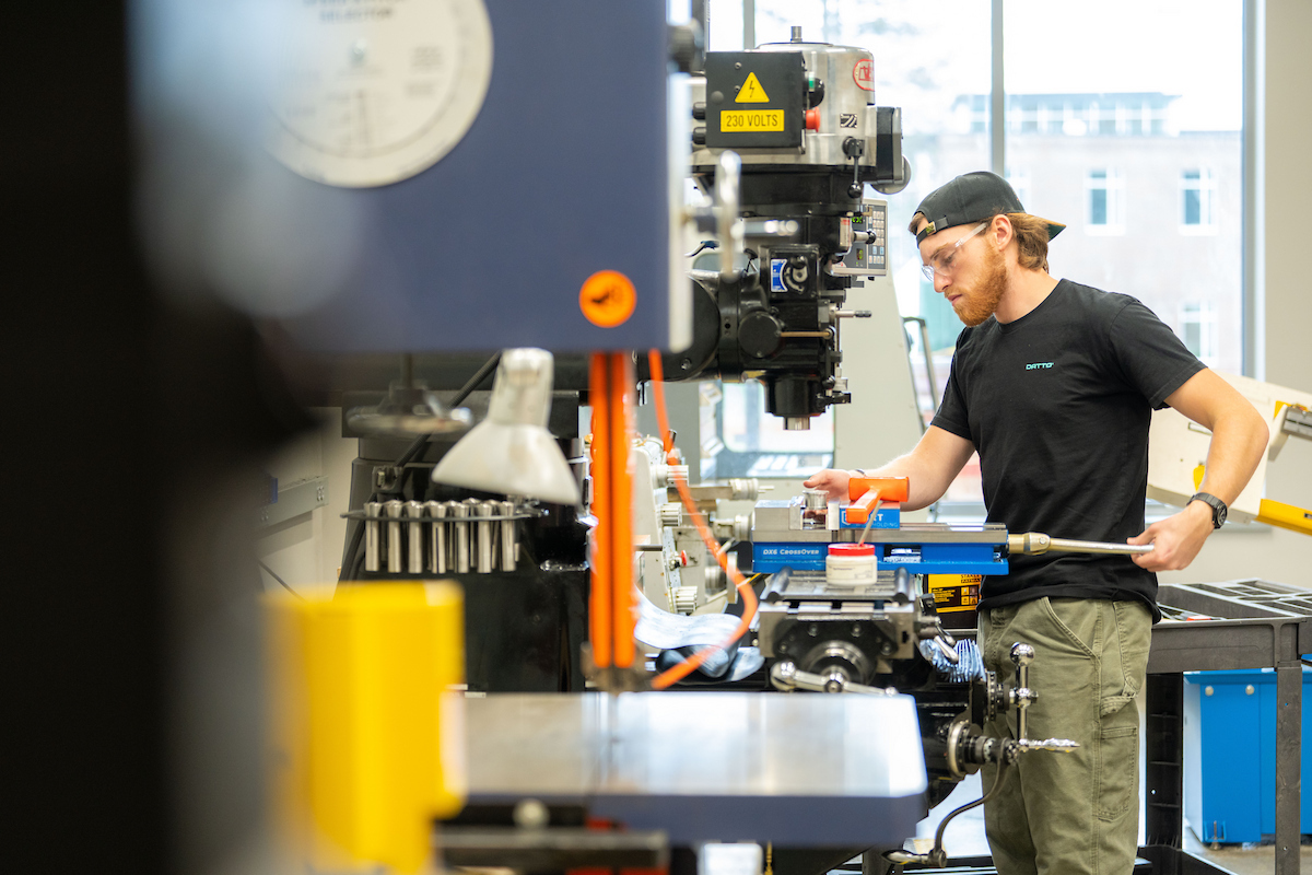 A photo of a student working with machinery 