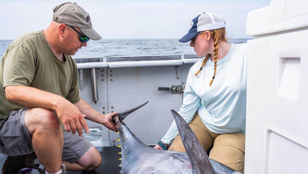 A photo of two people on a boat with a fish