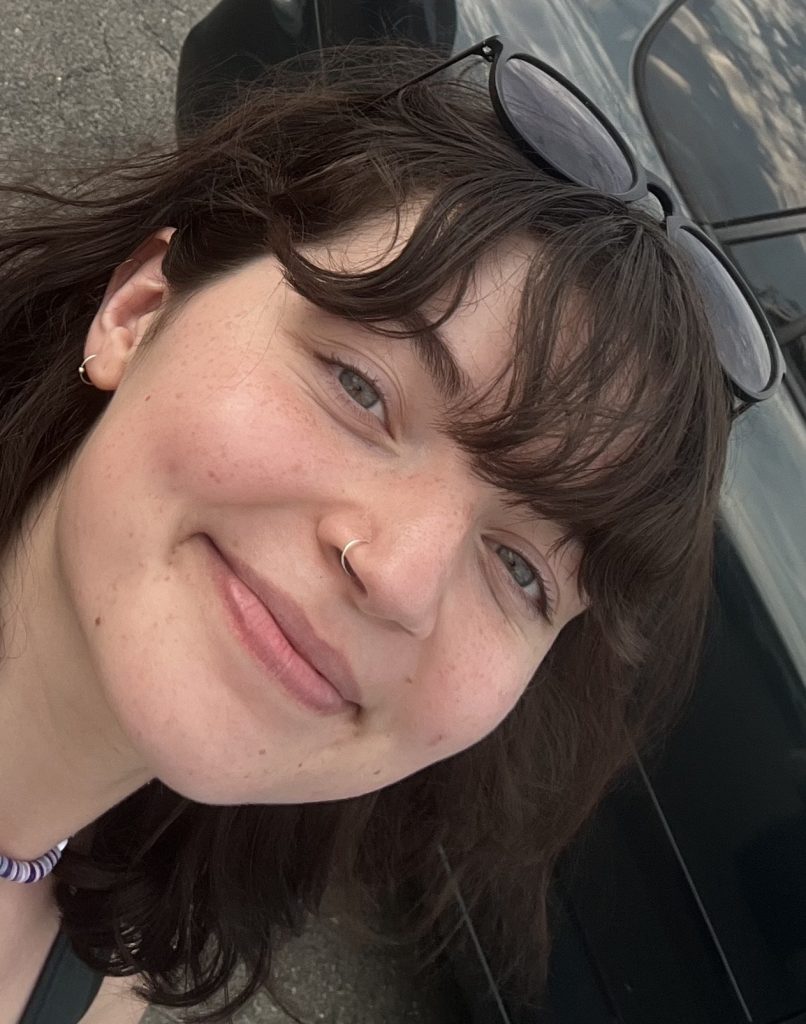 A girl (Kiera Campbell) smiling with sunglasses on her head.
