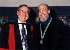 Two smiling men (Peter Hoff on the left, and Doug Allen on the right) at a graduation ceremony in their respective robes/suits.